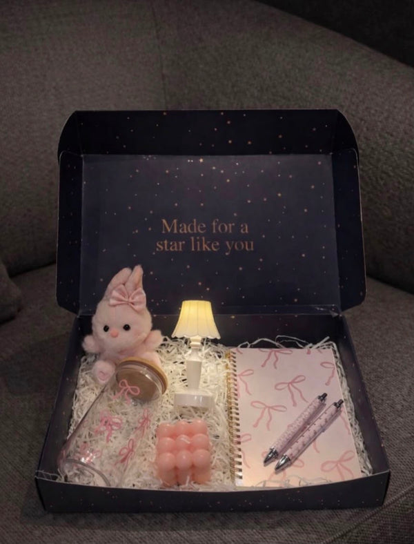 Candle + notebook + pen + lamp + bow-adorned mug + bunny plushie