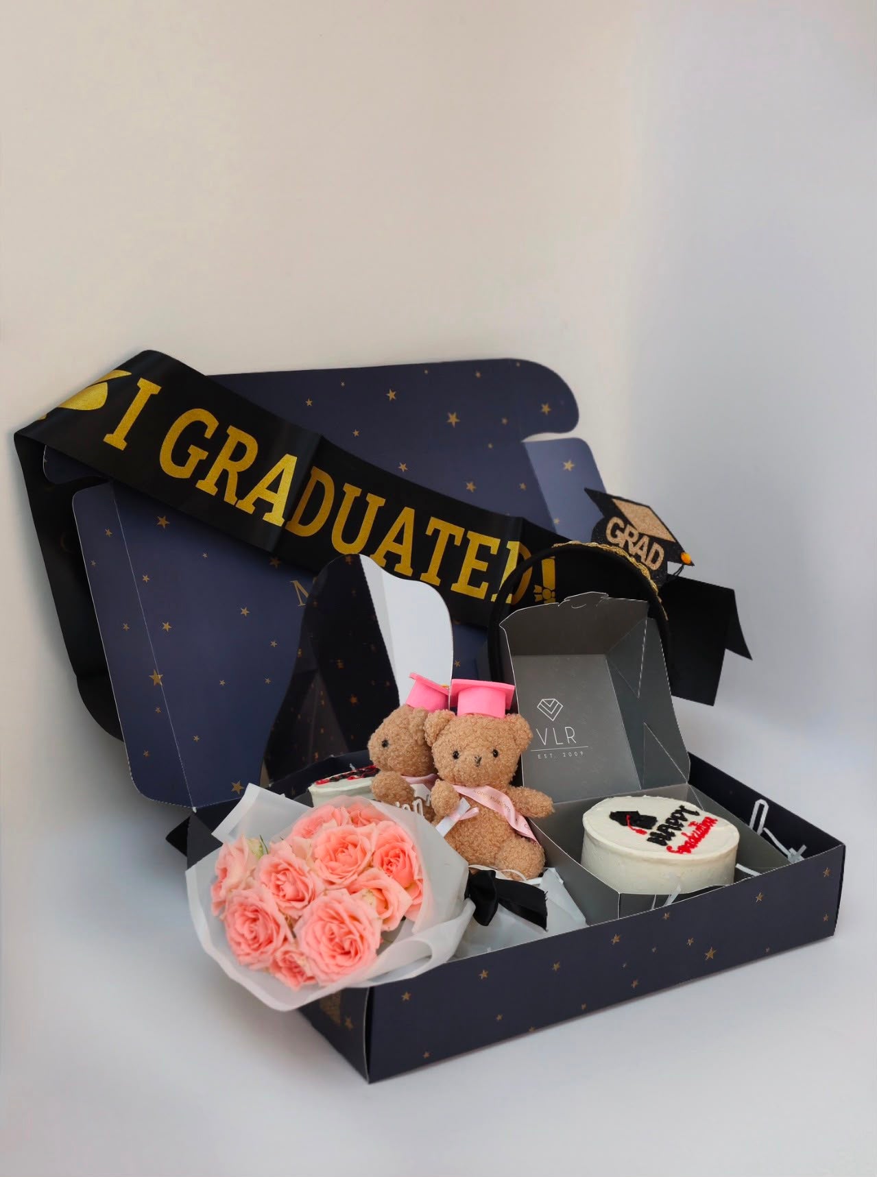 Cake + small teddy bear + crown with graduation sash + mirror + flowers